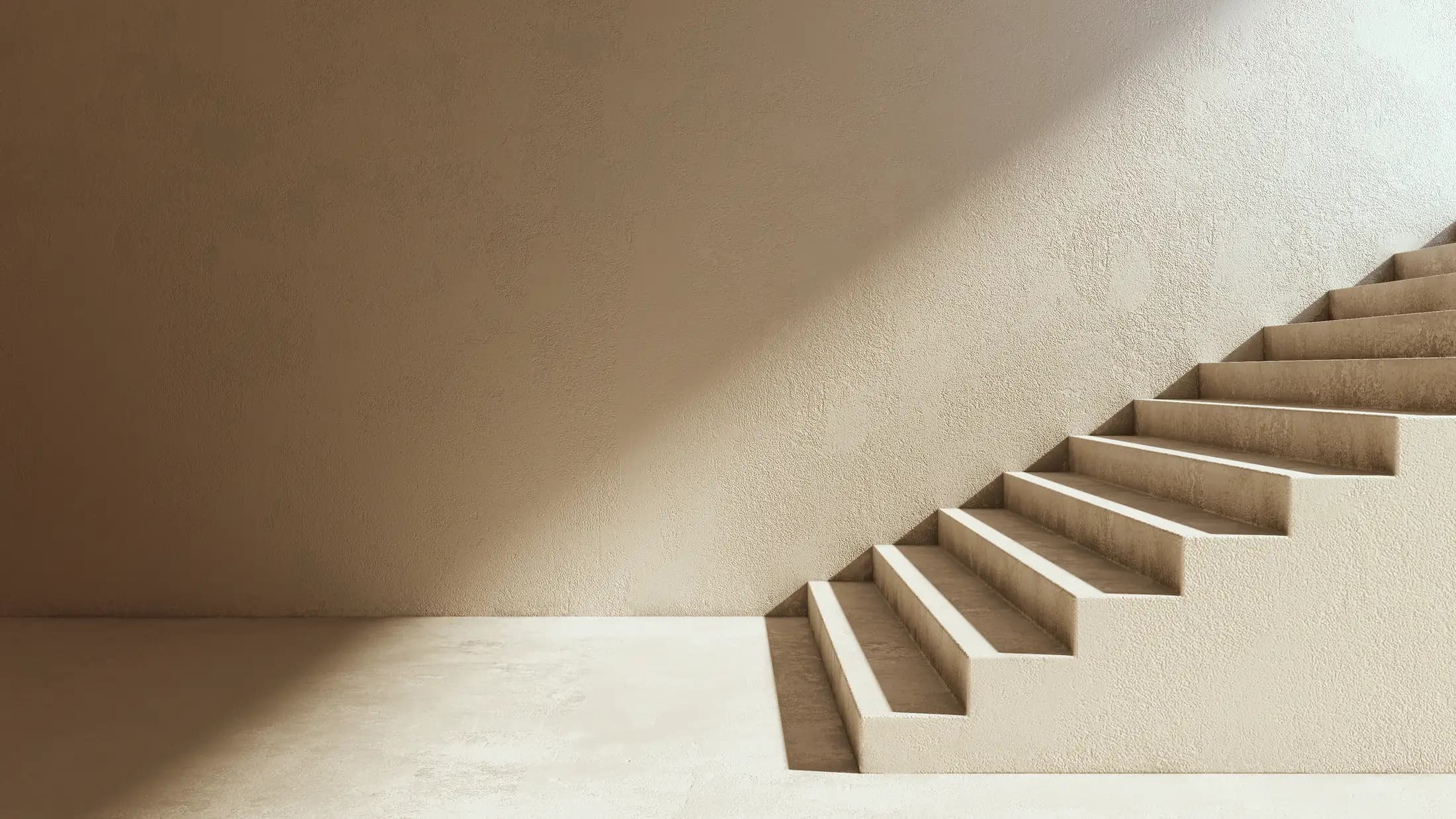 Helle Treppe, die vor einer warmen Wand Stufe für Stufe nach oben führt